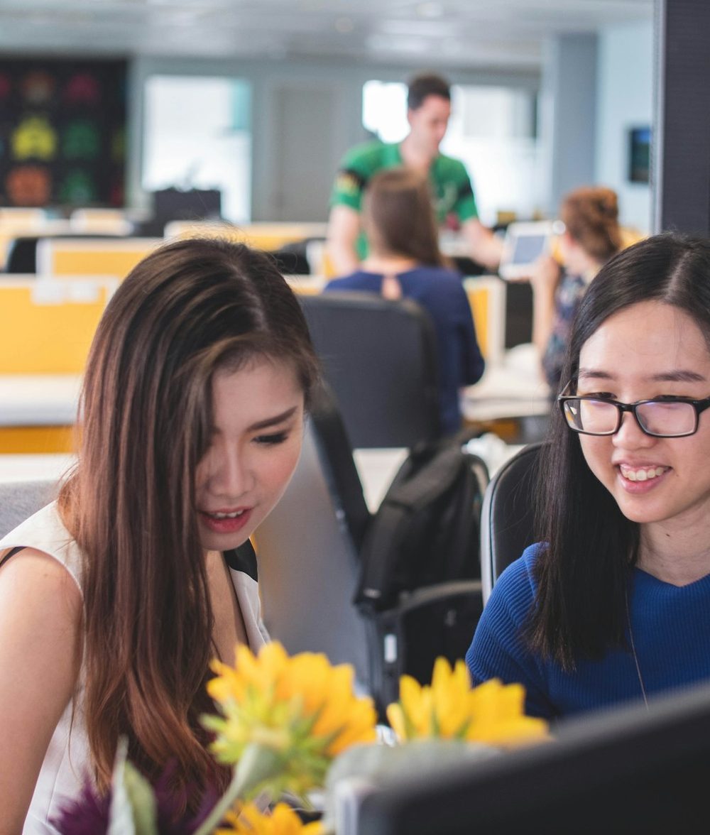 Two colleagues reviewing customer conversations on a screen