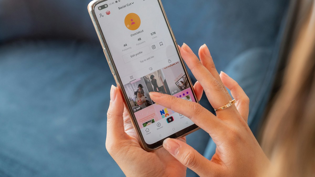 Seseorang menggulir feed media sosial di smartphone