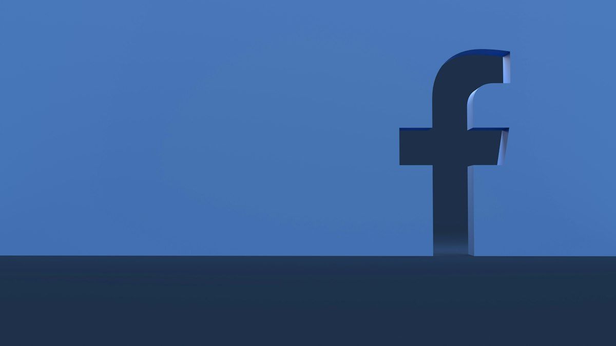 A three-dimensional Facebook logo on a blue background