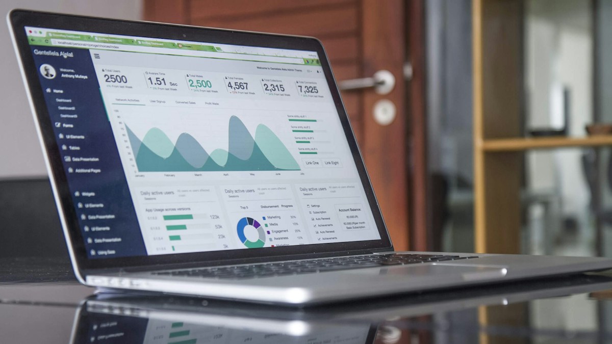 Laptop menampilkan grafik analitik di meja kerja