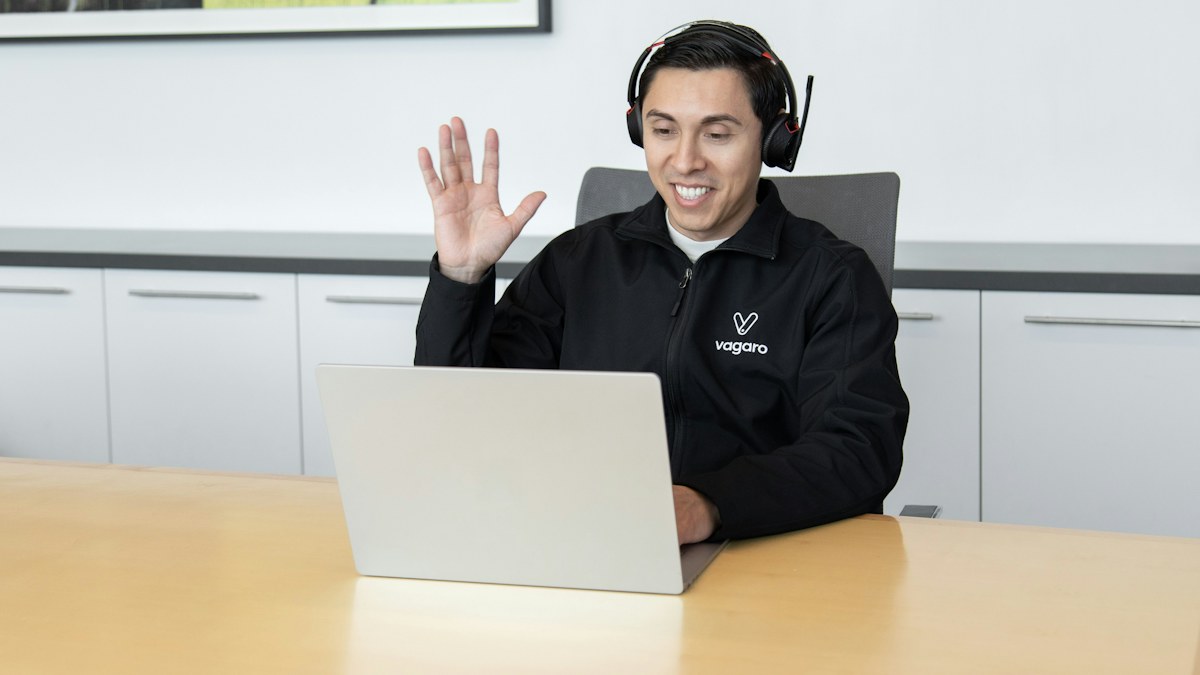 Agen customer service memakai headset melayani chat dari laptop