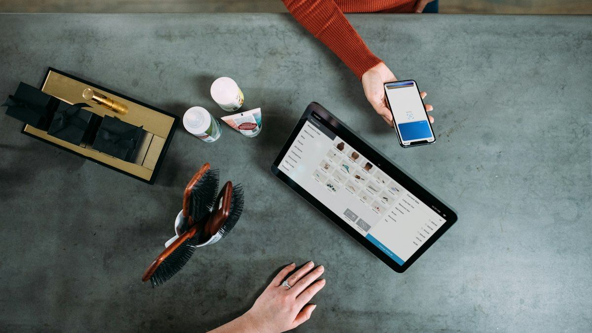 Smartphone dan tablet berisi data pesanan di atas meja
