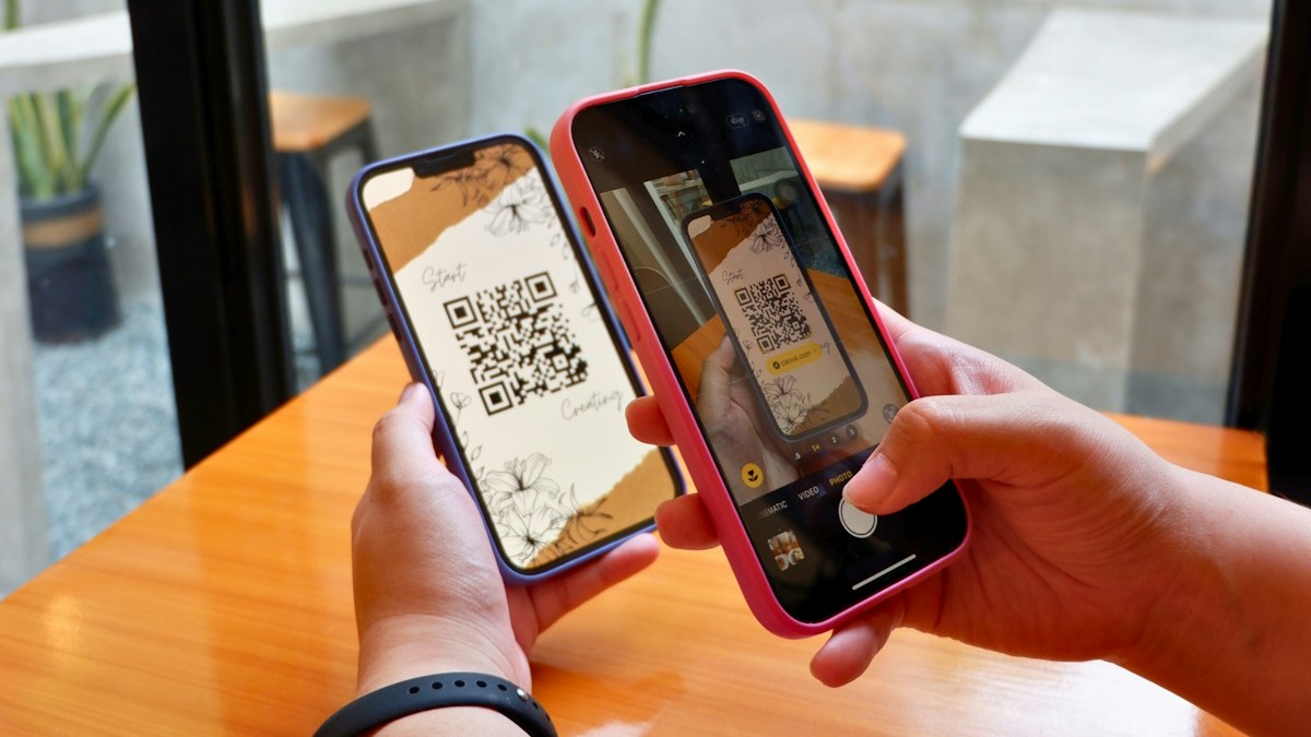 Pelanggan memindai QR code dengan smartphone di meja kasir
