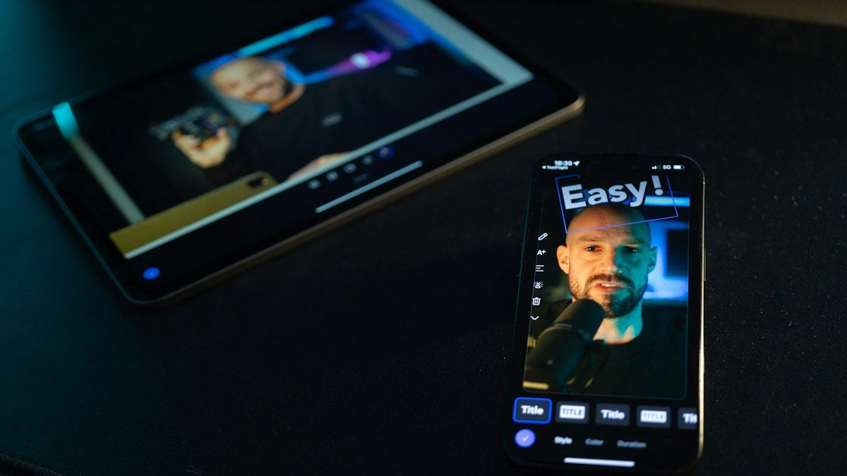 Smartphone memutar video kreator di samping tablet