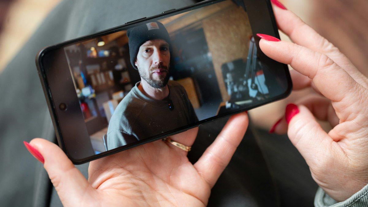 Tangan memegang smartphone yang memutar video