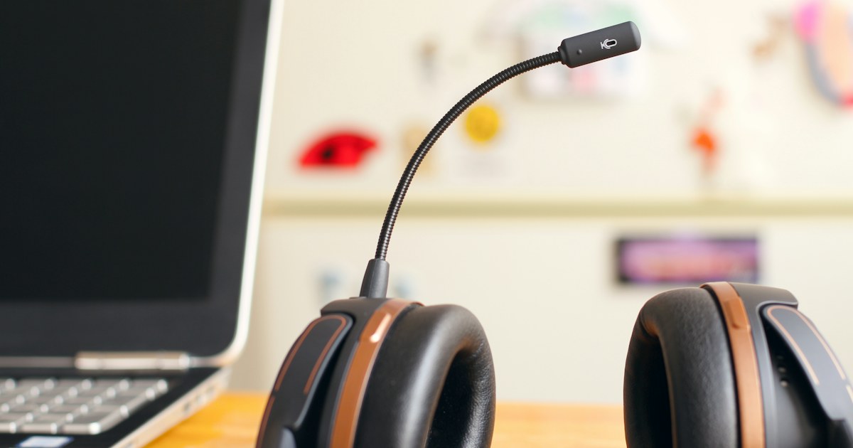 Headset di dekat laptop di meja kerja