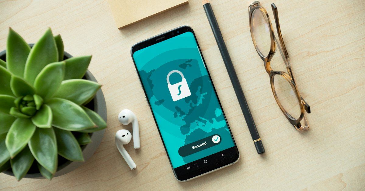 Smartphone menampilkan ikon gembok keamanan di meja kayu
