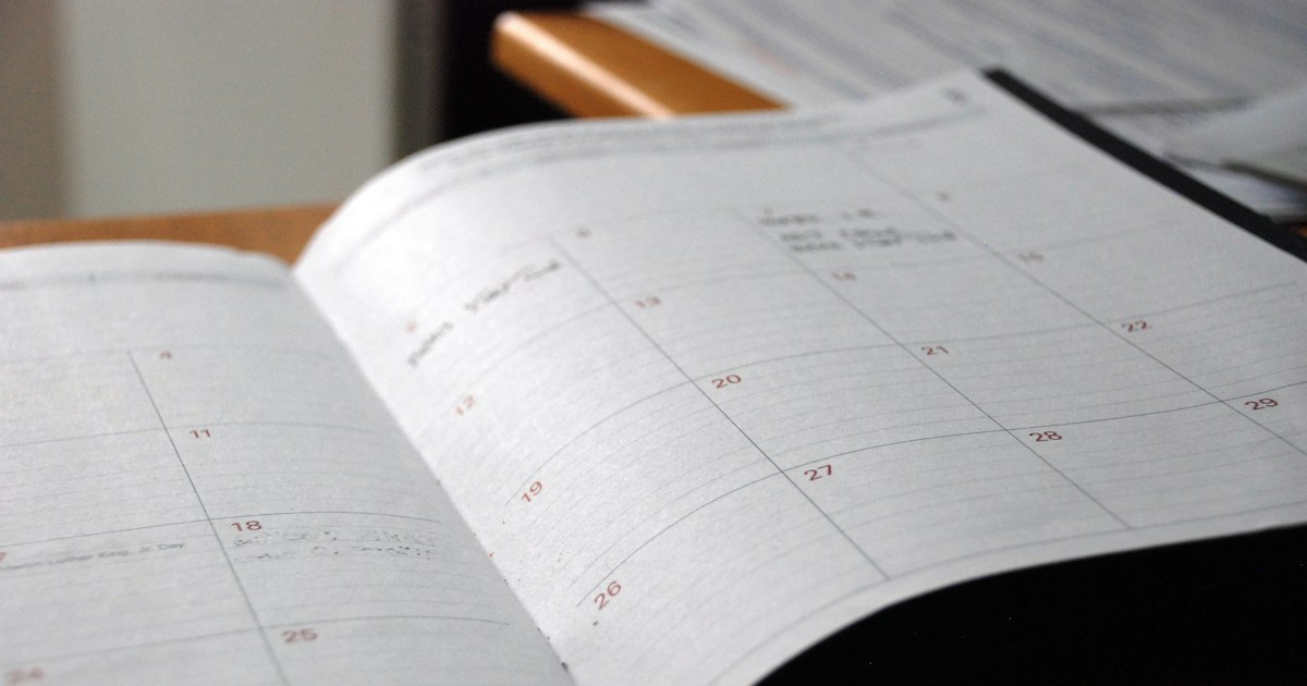Agenda bulanan terbuka di atas meja kayu